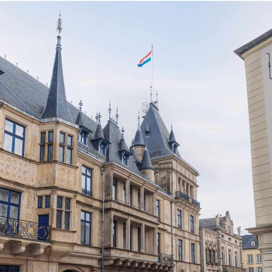 Grand ducal palace of luxembourg with luxembourg flag waving at the top