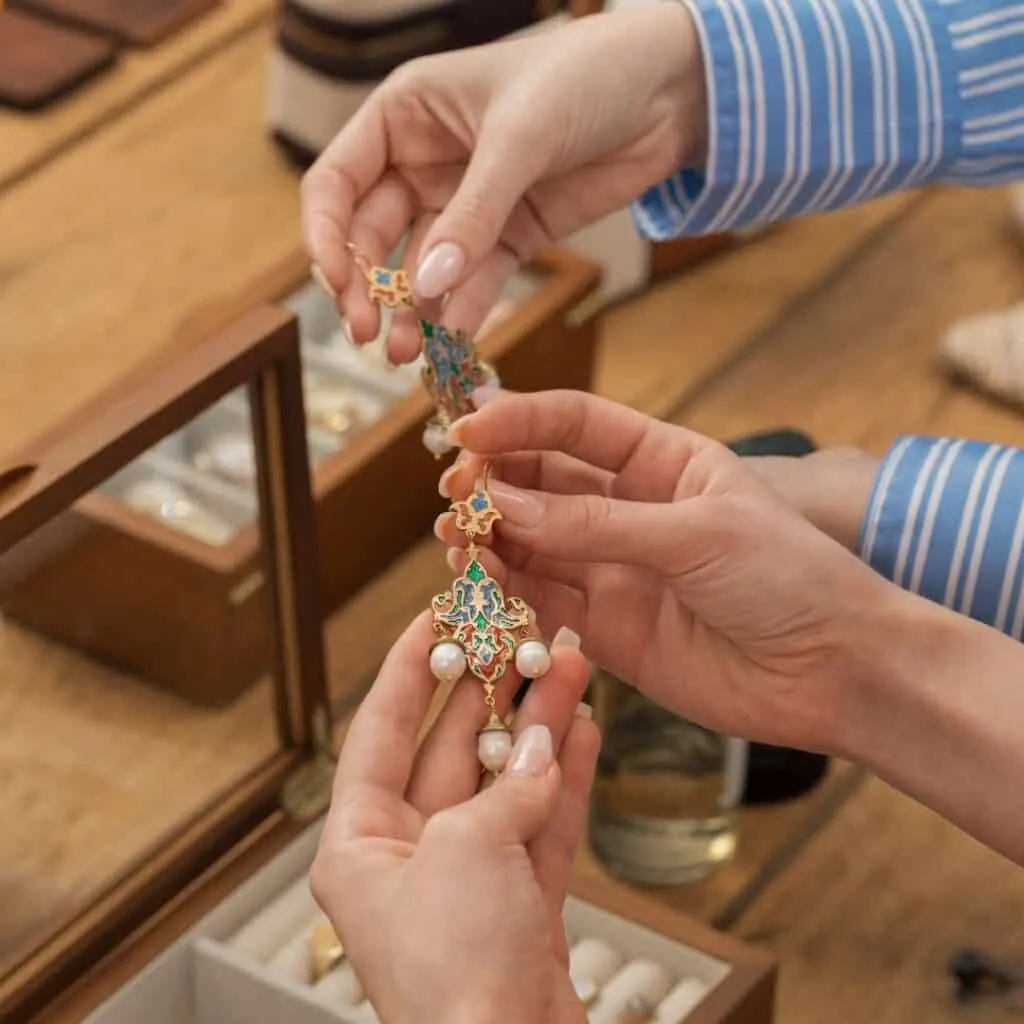 hands picking up elaborate vintage jewelry in downtown antique shop in lake geneva wisconsin