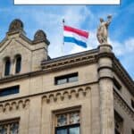 Pinterest pin about interesting facts about luxembourg showing photo of luxembourg flag on top of traditional building