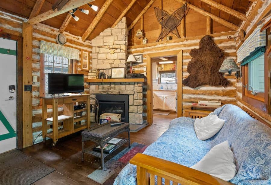 living room with fire place and sofa at Authentic Log Cabin - Incredible Scenery in Ephraim, Wisconsin