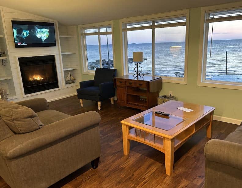 living room with sofa and TV overlooking the lake at Port Cottage in Sturgeon Bay, Wisconsin
