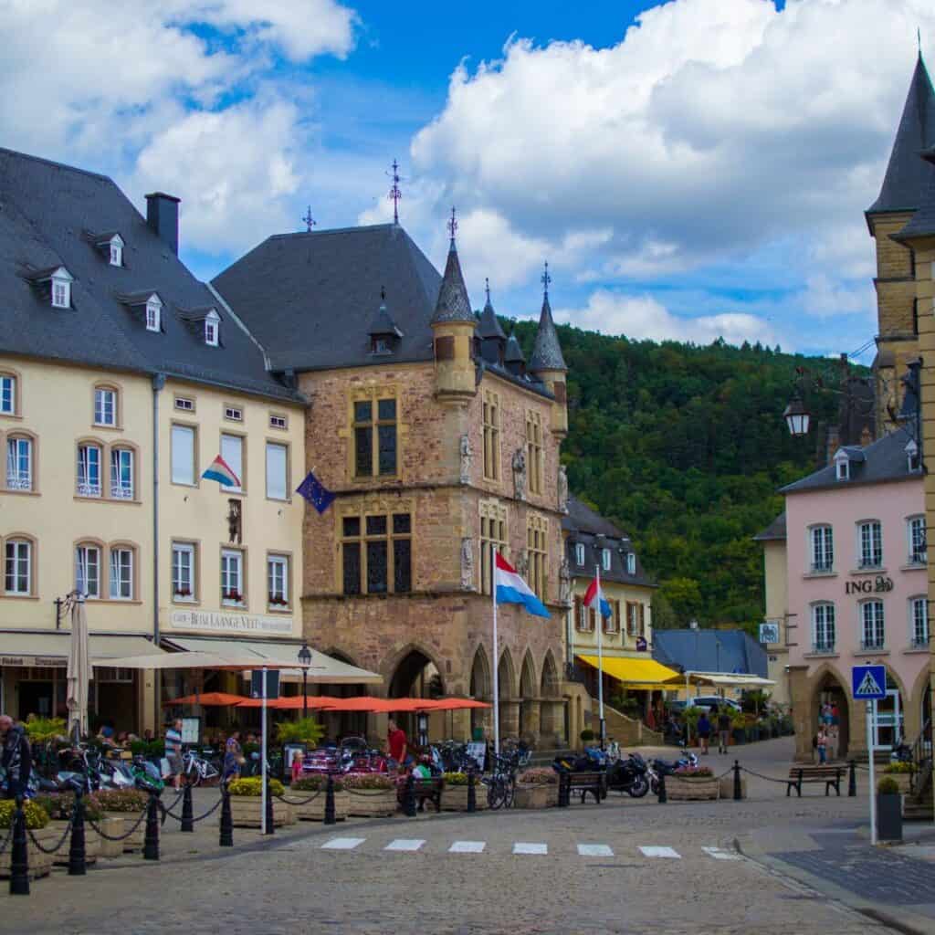 old buildings with small cafes and a luxembourg flag in main square of echternach