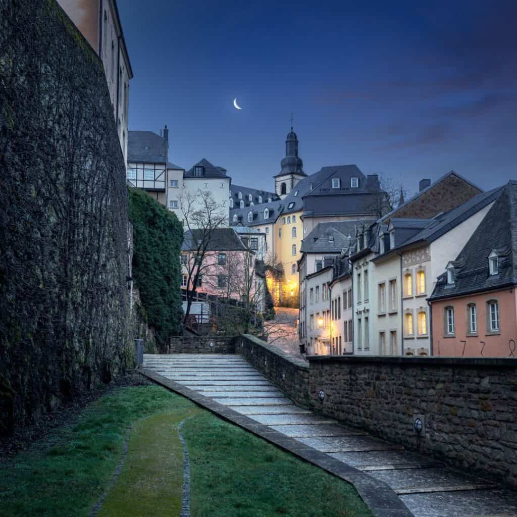 streets of luxembourg at night with moon in the background