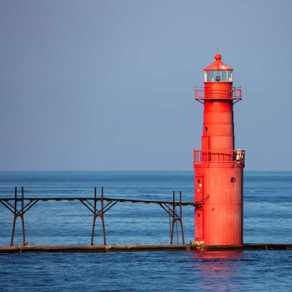 a red lighthouse in the middle of the ocean