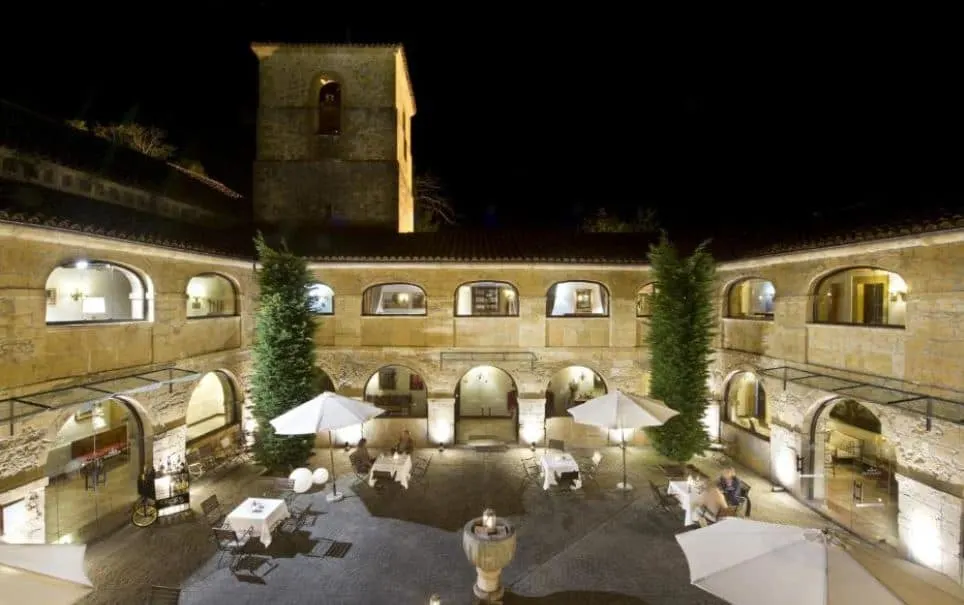 Parador de Cangas de Onís in Spain at night with people sitting in the garden