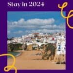 a pin with a beach landscape with building in the back, Where To Stay In Albufeira