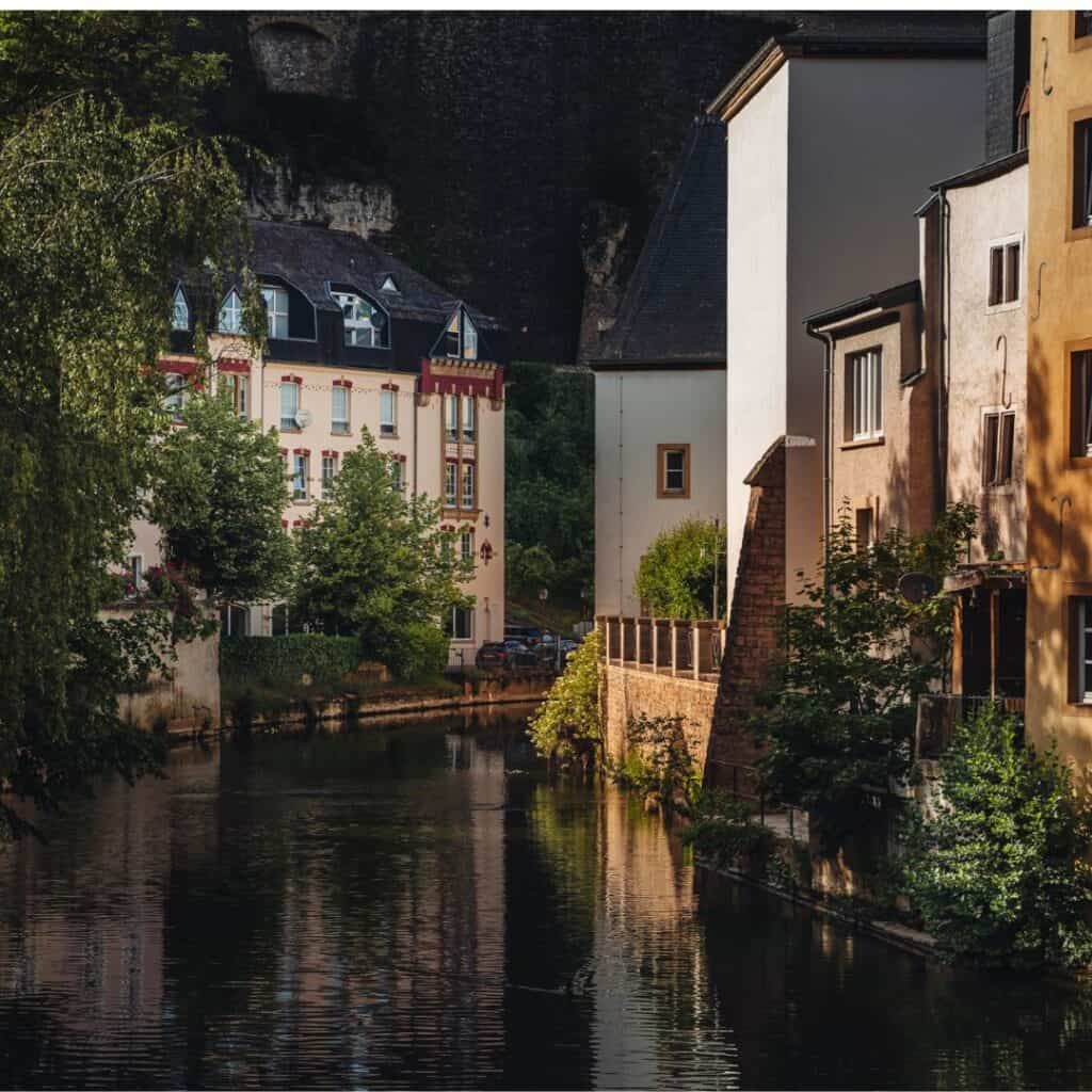 Photo of the Alzette River winding through the historic Grund neighborhood in Luxembourg City at night