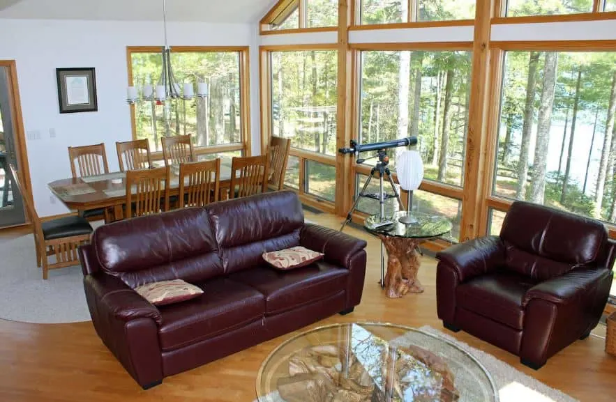 living room with lake view, sofas and dining area at the Secluded Hideaway with Private Dock in Bayfield, Wisconsin