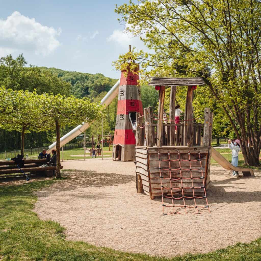A vibrant children's playground nestled amidst the lush greenery of Parc de la Ville in Luxembourg