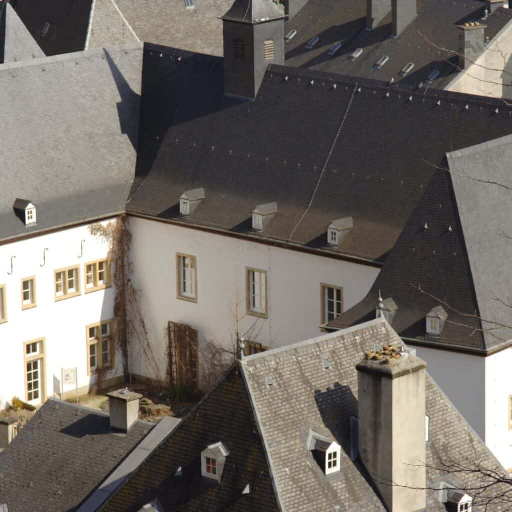 Detail of the exterior of Urspelt Castle, Luxembourg, showing slate roofs and chimneys.