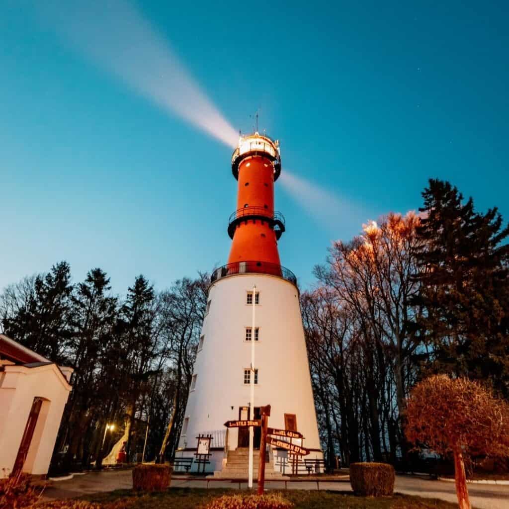 a red and white lighthouse is lit up at night