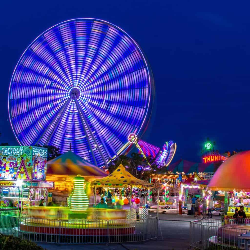 A vibrant Ferris wheel dominates the Schueberfouer Fair, a lively summer festival in Luxembourg. Thrill-seekers enjoy exhilarating rides under the twinkling lights.