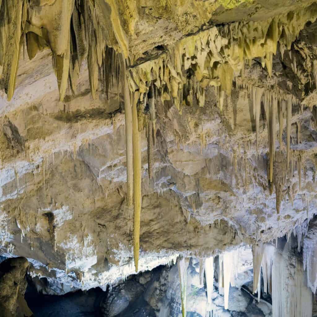 A close-up of the intricate formations of stalactites and stalagmites in the Antiparos Cave, highlighting their delicate and otherworldly appearance.