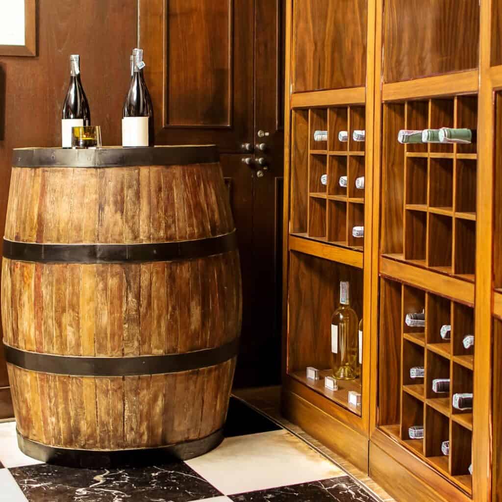 a wine cellar wine bottles on top of a wooden barrel and shelves