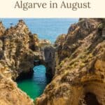 Pinterest pin about Algarve in August showing a photo of a sandy beach with towering cliffs and rock formations scattered throughout, including a blue ocean with whitecaps on the waves, and a clear blue sky.