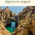 Pinterest pin about Algarve in August showing a photo of a sandy beach with towering cliffs and rock formations scattered throughout, including a blue ocean with whitecaps on the waves, and a clear blue sky.