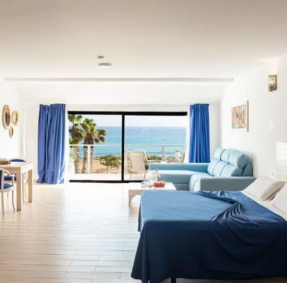 bedroom with a sofa and balcony overlooking the sea at Hotel LIVVO Budha Beach in Cape Verde