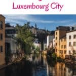 Pinterest pin about fun things to do in luxembourg city showing the afternoon view of the Grund neighborhood in Luxembourg City, featuring the Alzette River winding through the historic district with colorful facades lining the waterfront.