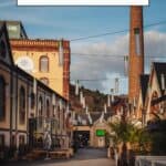 Pinterest pin about fun things to do in luxembourg city showing a photo of a row of colorful buildings with a tall chimney in the Clausen district of Luxembourg City. In the background, there are modern buildings of the European quarter.