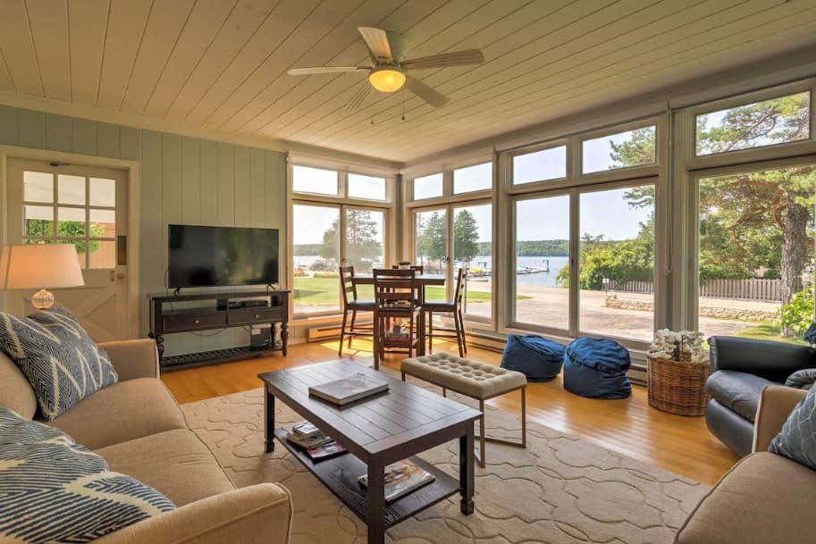 living room with sofa and TV with big windows overlooking the lake at Boutique Home in Door County with Eagle Harbor Views