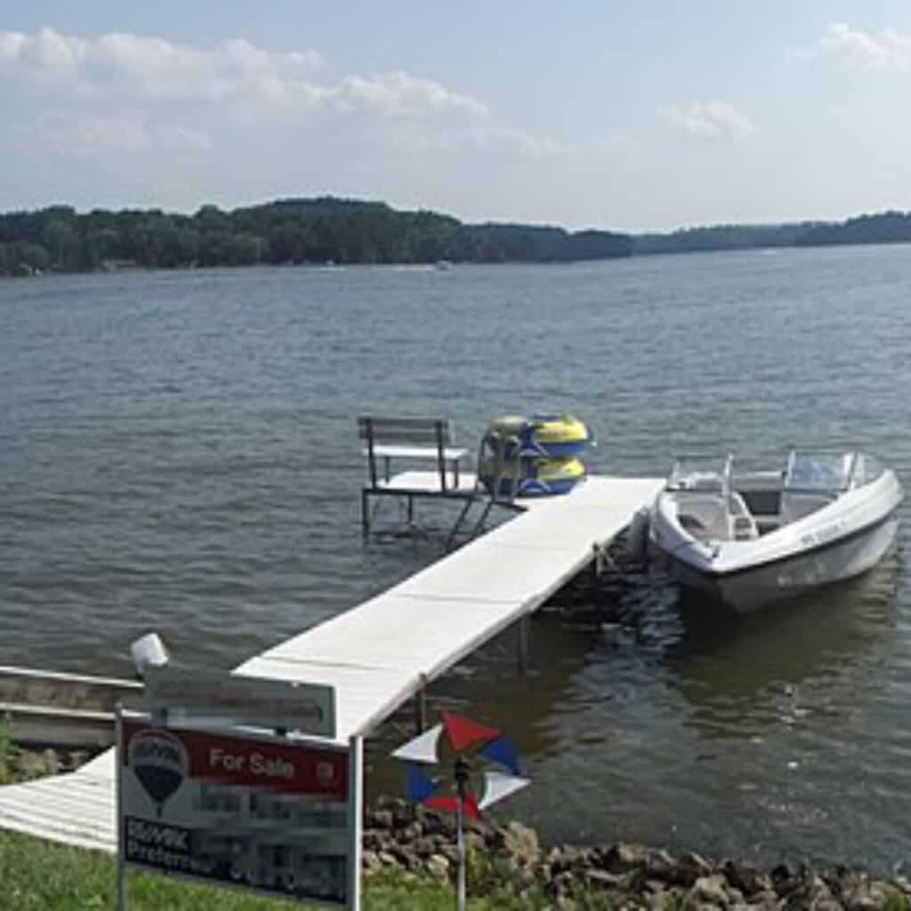 a boat docked at the end of a dock next to a lake, one of the best lakes near wisconsin dells