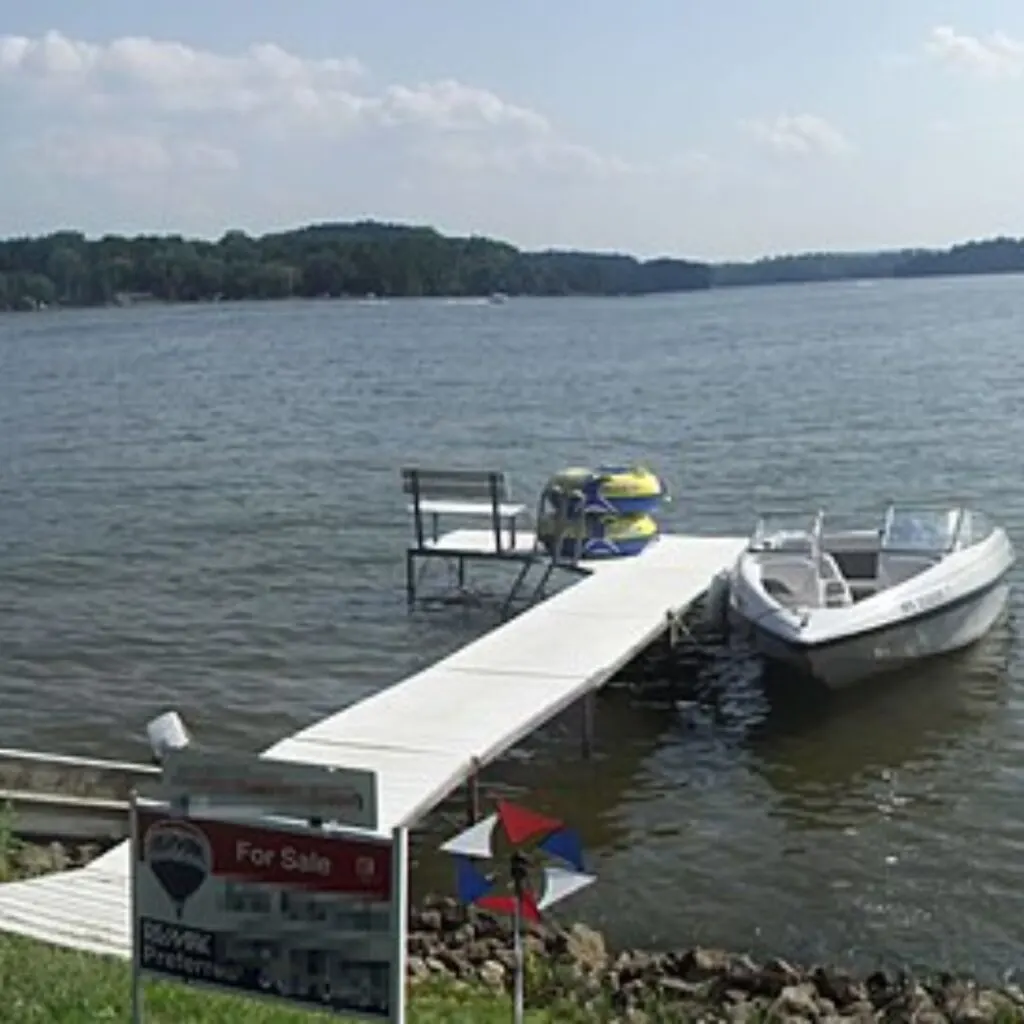 a boat docked at the end of a dock next to a lake, one of the best lakes near wisconsin dells