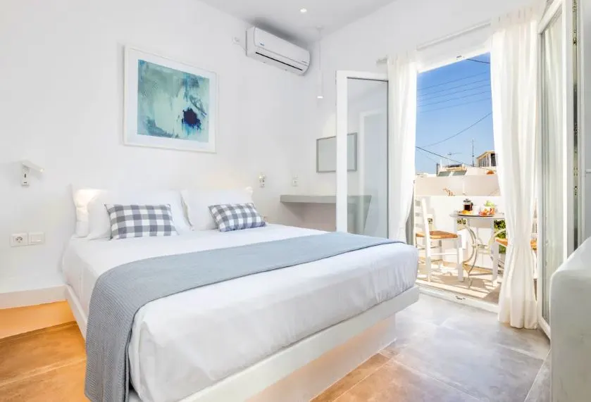 bright room with bed and balcony at Pelican Paros in Greece