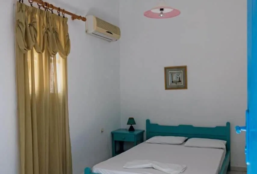 cozy and simple room with a bed at Miltiadis Apartments in Paros, Greece