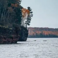 kayakers make their way through the sea caves at the apostle islands national lakeshore in wisconsin