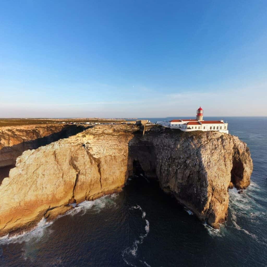  A photo of Cabo de São Vicente, the southwesternmost point of mainland Europe. The image shows a white lighthouse perched on a dramatic cliff overlooking the ocean.