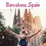 A person with arms outstretched in front of Sagrada Familia, Barcelona, Spain