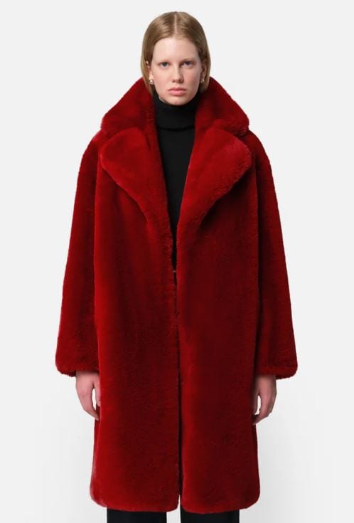 a woman wearing a red knee length steffi faux fur coat