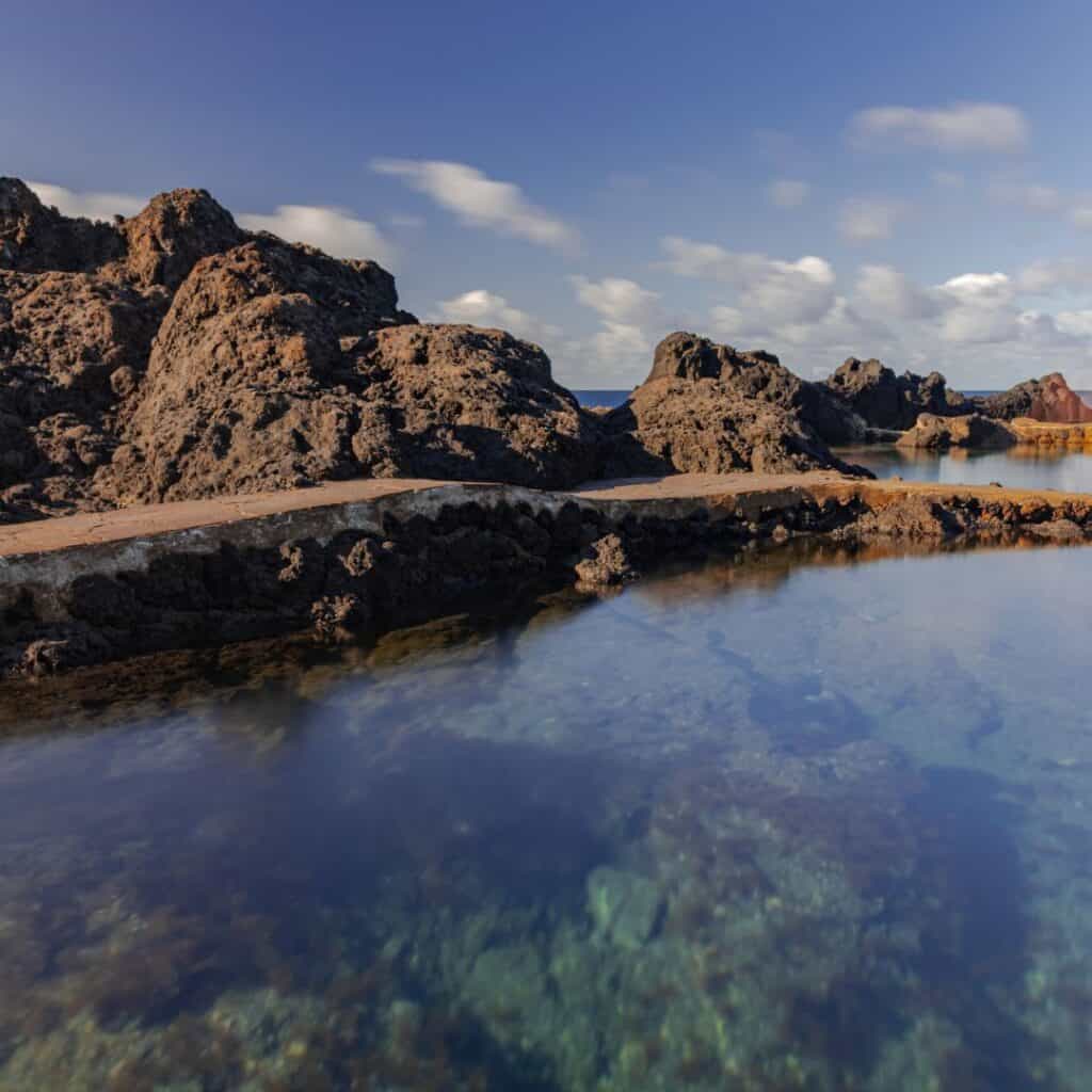 a body of water surrounded by rocks in the middle of the ocean