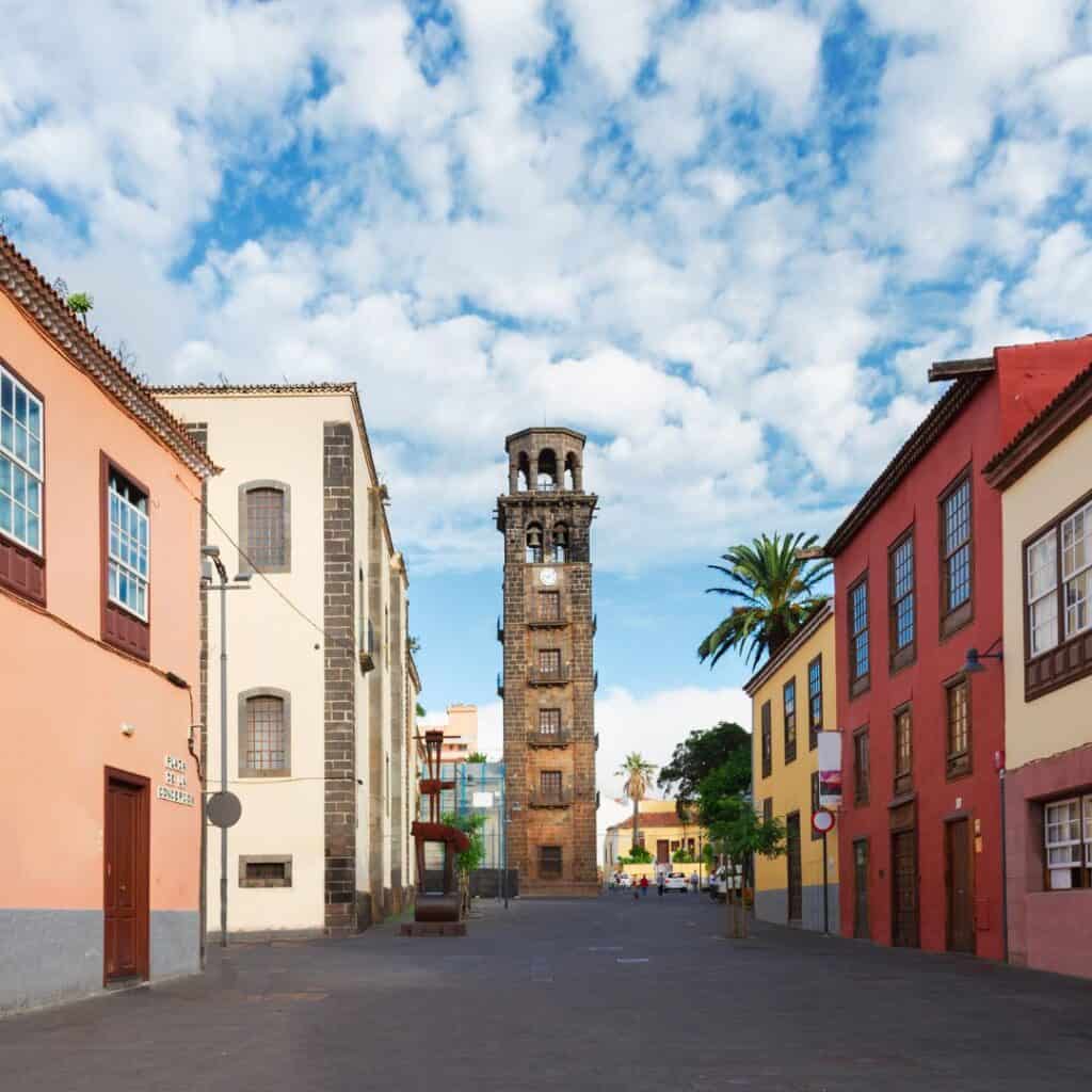 a street with colorful buildings with a clock tower in the middle of it