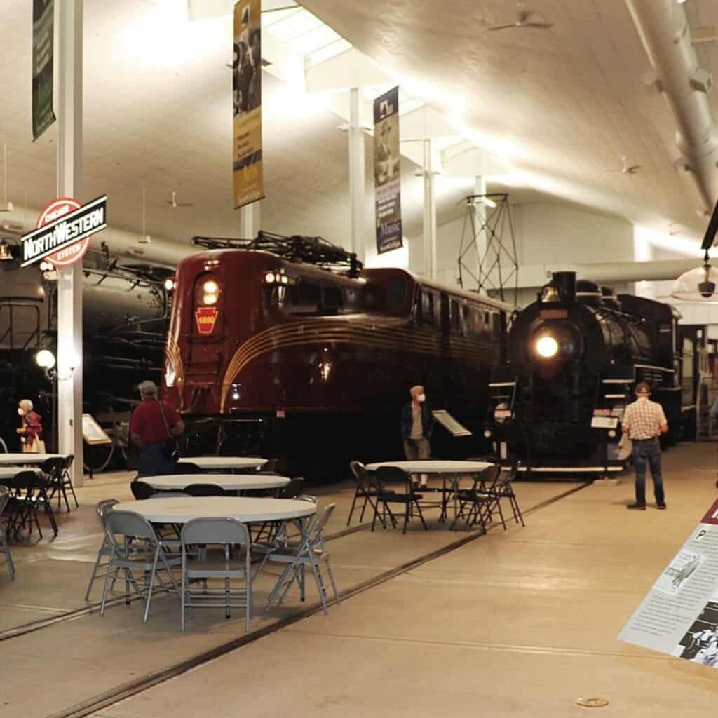 a large room with tables and chairs and a train on display