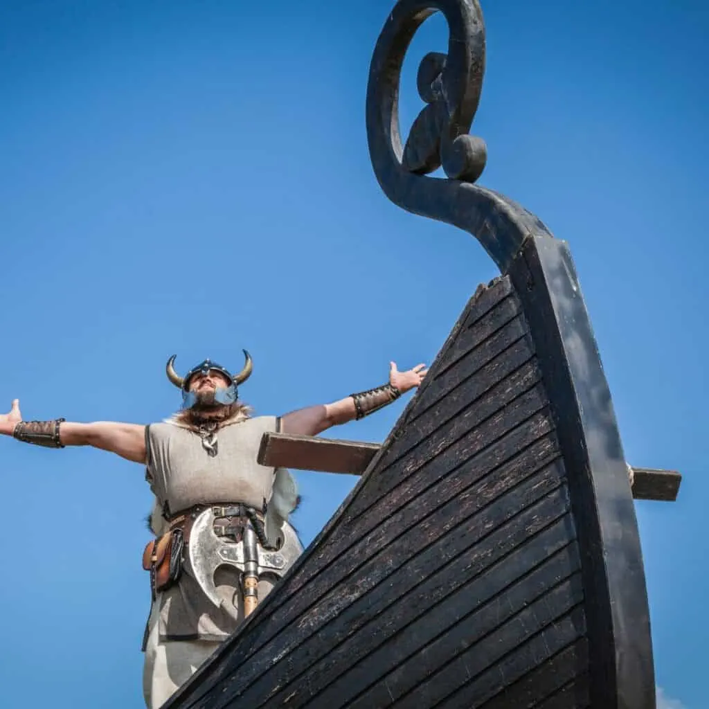 a person is standing on top of a wooden boat