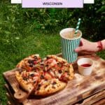 a wooden table topped with a pizza and a cup of coffee
