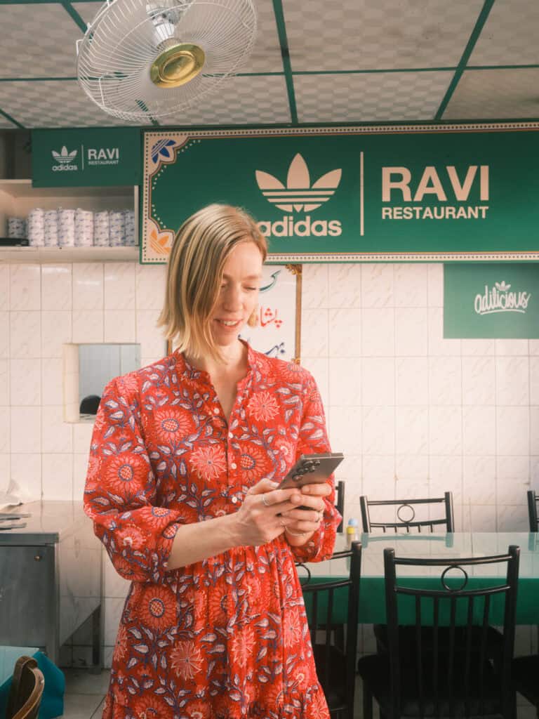 a woman in a red dress in a restaurant looking at her phone