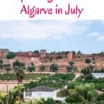 ruins of the castle of silves in distance behind homes and greenery