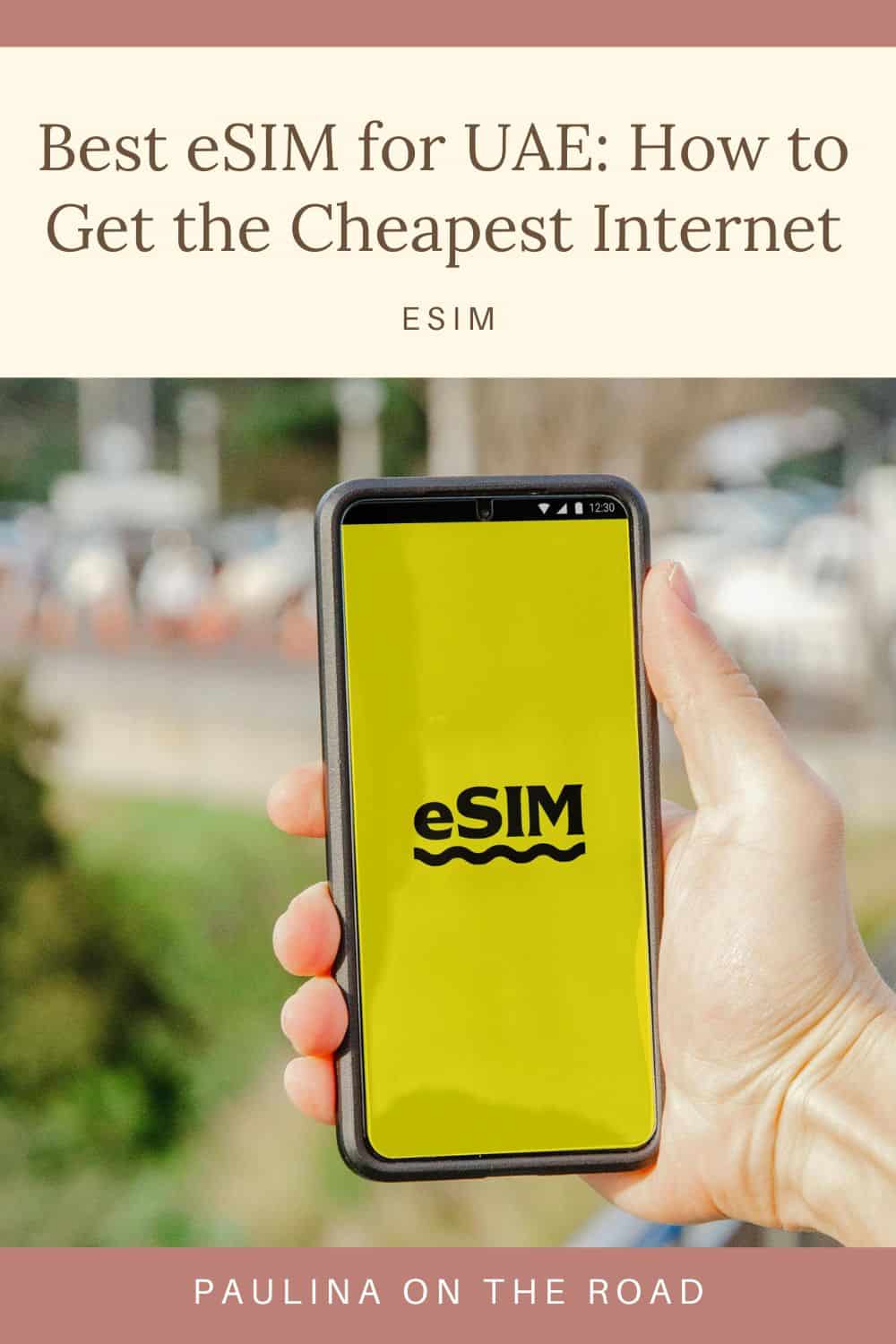 a phone with a yellow screen and eSIM text held by a person's hand