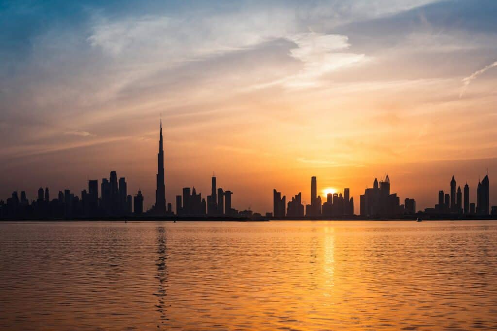 Enchanting view of Dubai's skyscrapers at sunset with the iconic Burj Khalifa outlined against the vivid sky.