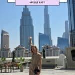 This image shows a person standing on a terrace with a view of the Burj Khalifa in Dubai.