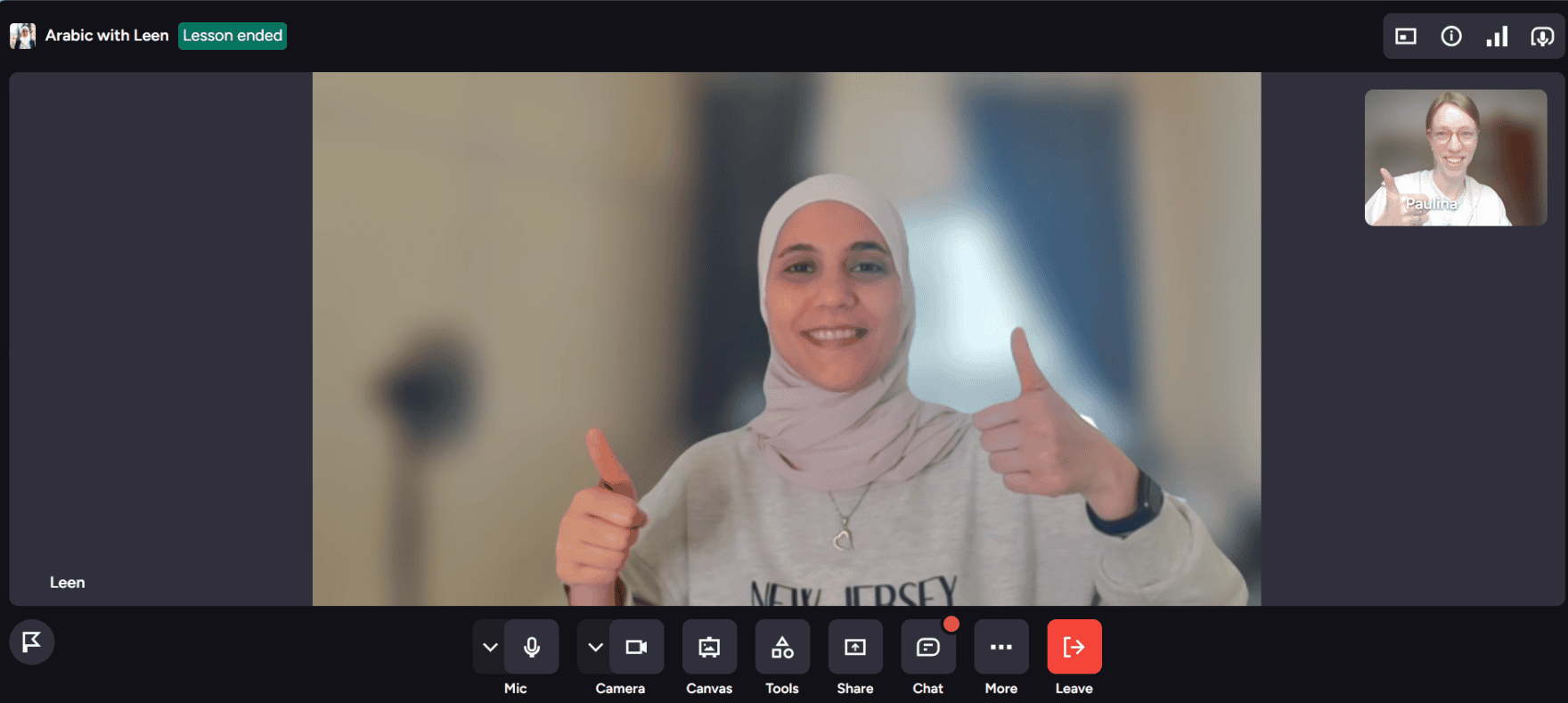 a woman in hijab with her two thumbs up in a screen with a woman who is learning Arabic