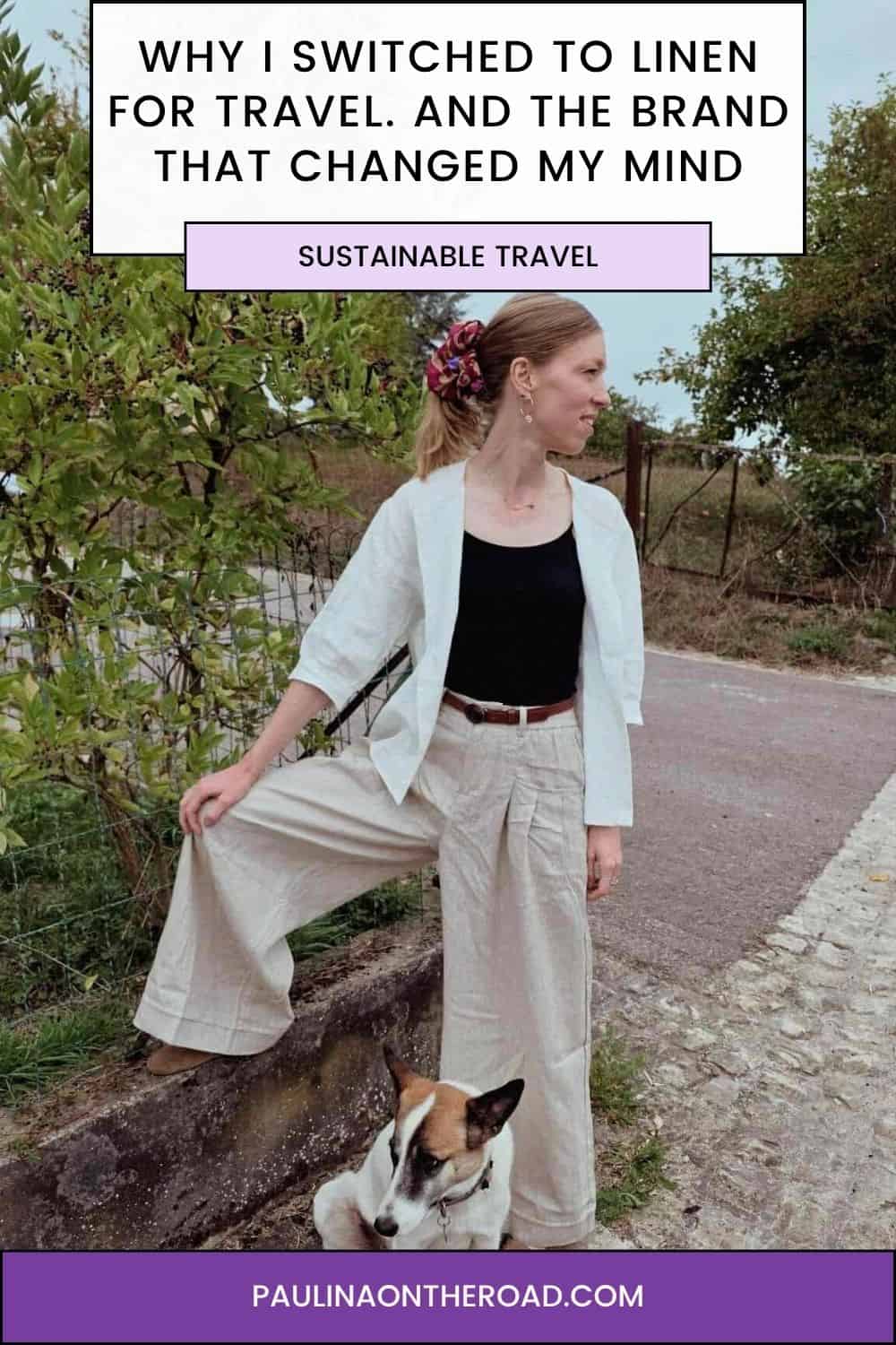 Woman wearing a black shirt, white top, and linen pants with a dog near a garden at the background