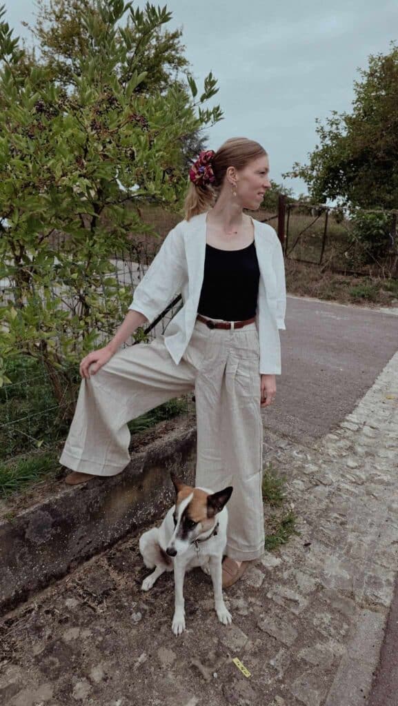 Why I Switched to Linen for Travel Lintico Discovery | Paulina | Woman wearing a black shirt, white top, and linen pants with a dog near a garden at the background