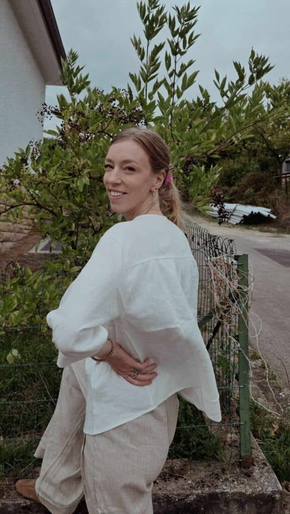 Why I Switched to Linen for Travel Lintico Discovery | Paulina | Woman wearing a white top, and linen pants with a garden at the background